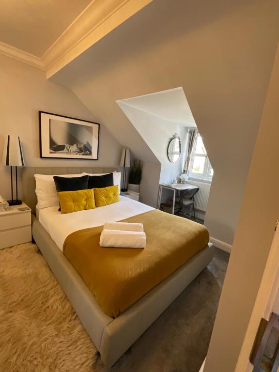 a bedroom with a large bed with yellow pillows at Home away from home in London