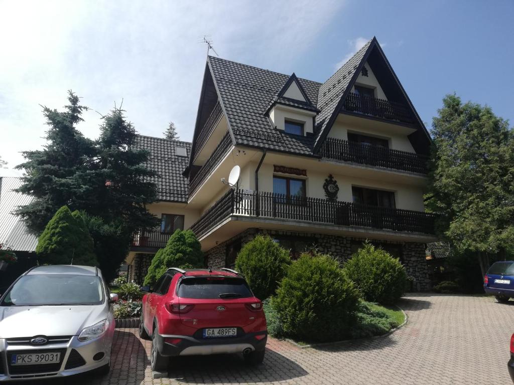 a house with two cars parked in front of it at Willa Marianna in Zakopane