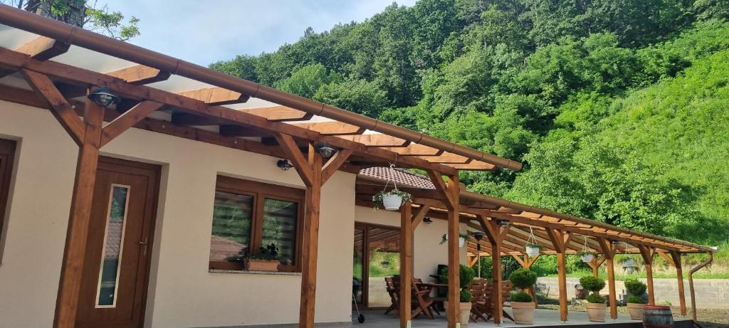 a wooden pergola on a house with a mountain at HŐS Vendégház MISKOLC -önálló vendégház, mely csak az Önöké in Miskolc