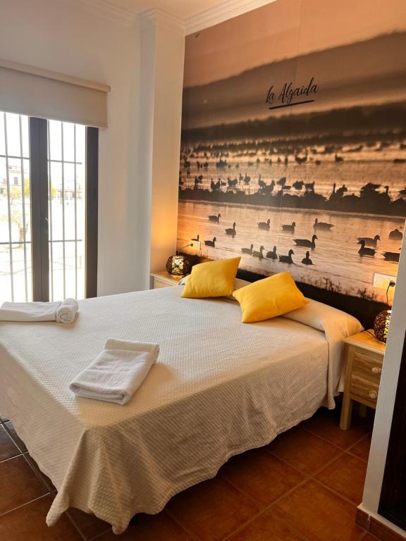 a bedroom with a large bed with towels on it at Alojamiento Rural El Sombrero in El Rocío