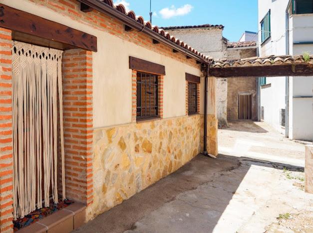 een oud bakstenen gebouw met een open deur en ramen bij La cuadrita in Uña