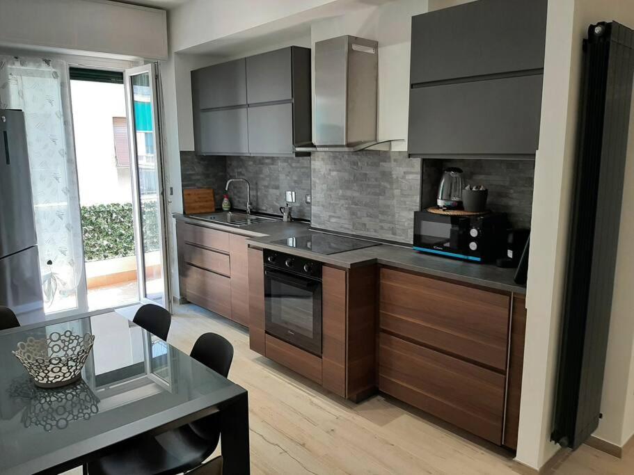a kitchen with stainless steel appliances and a dining table at Titti's House - Parcheggio custodito in garage gratis in Genoa