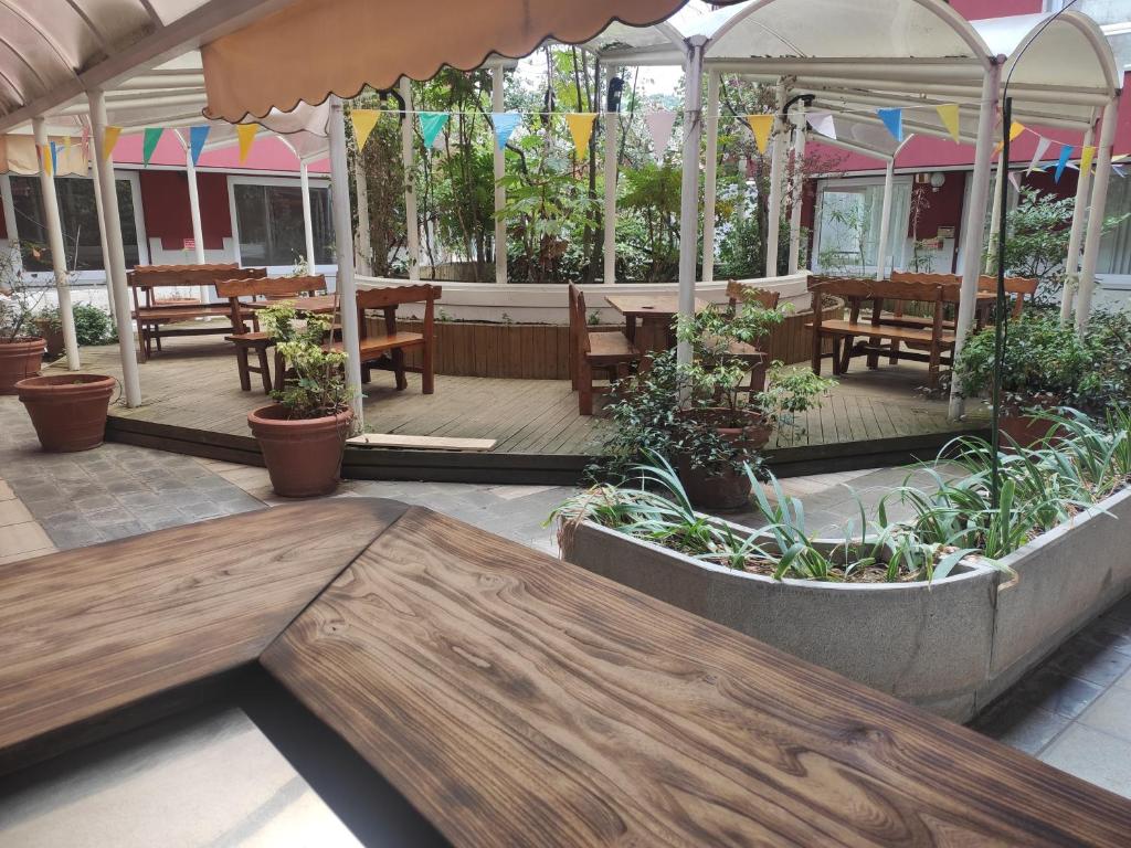 un patio al aire libre con mesas, sillas y plantas en Albergo Al Trieste, en Nimis
