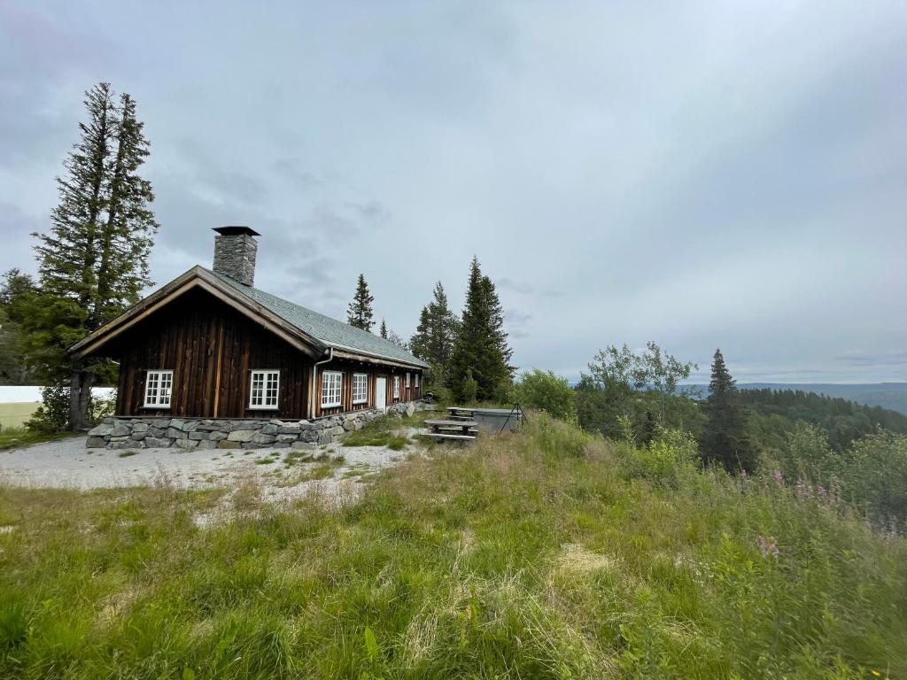 uma pequena cabana no topo de uma colina em Grindastugu cabin right by Liatoppen Ski Centre. em Al