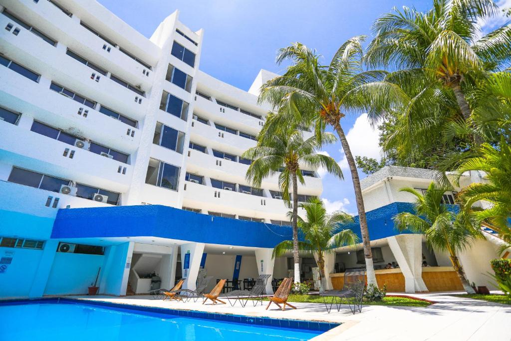 a large building with palm trees and a swimming pool at Hotel Caribe Internacional Cancun in Cancún