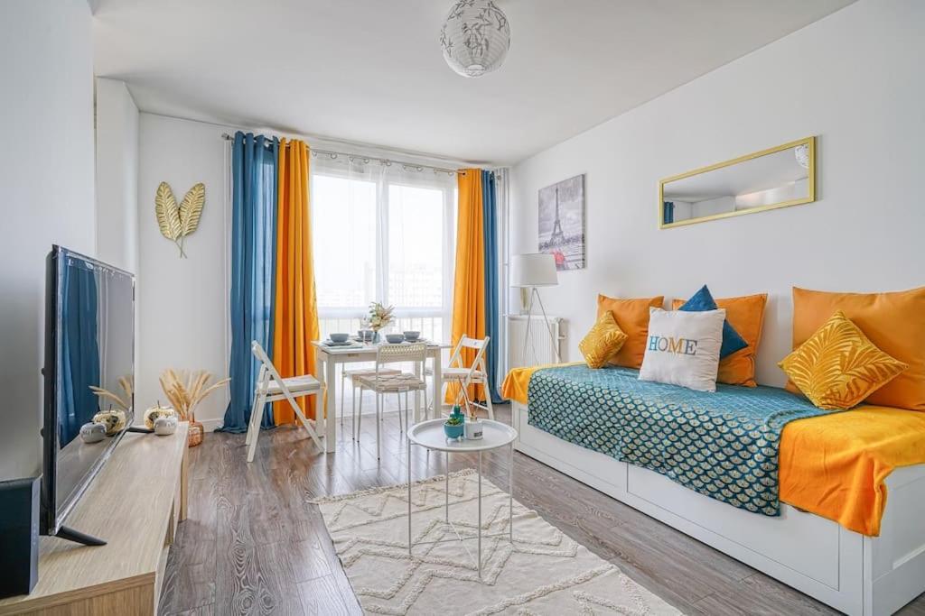 uma sala de estar com uma cama e uma mesa em Saphir T2 proche Paris em Vitry-sur-Seine