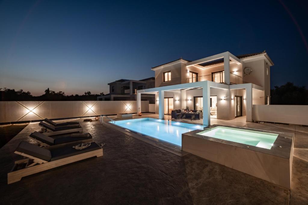 a villa with a swimming pool at night at Ionian Escape in Zakynthos Town