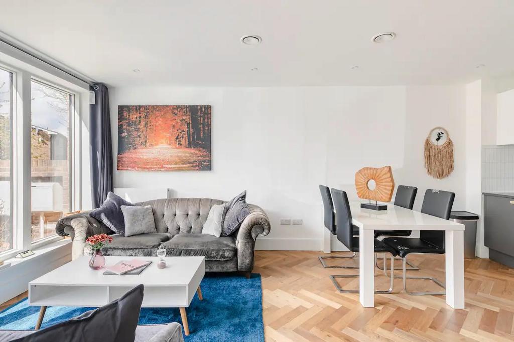 a living room with a couch and a table at A Modern Lavish En-suite Bedroom in London