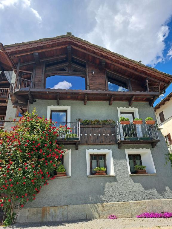 una casa con balcones y flores frente a ella en Baita LE SERE en Sestriere