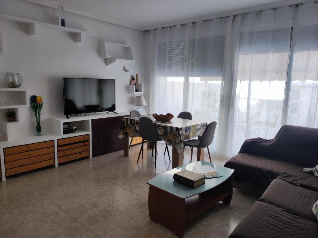 sala de estar con sofá y mesa con sillas en Piso céntrico reformado de excelente ubicación en Vinarós