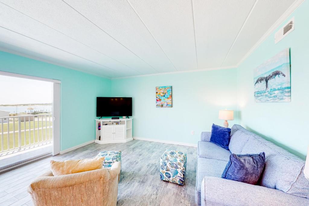 a living room with a couch and a tv at Assateague House 306 in Ocean City