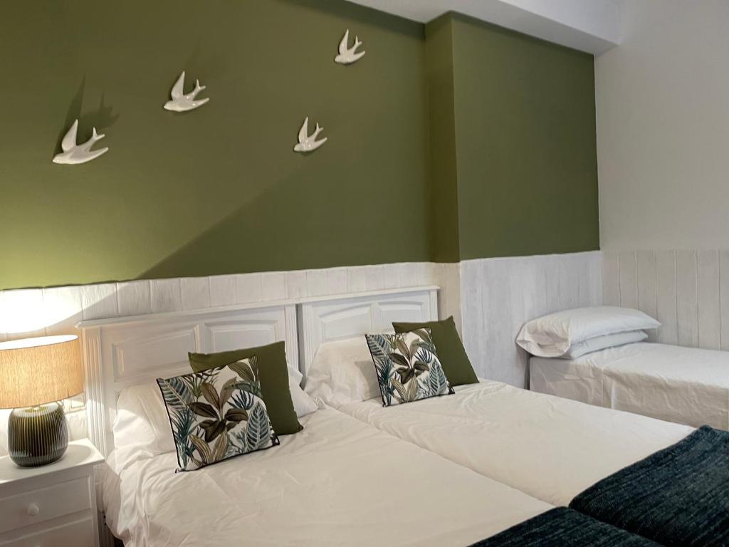 a bedroom with two beds with white butterflies on the wall at Close to Sierra Nevada Casa Rural Las Golondrinas in Güéjar-Sierra