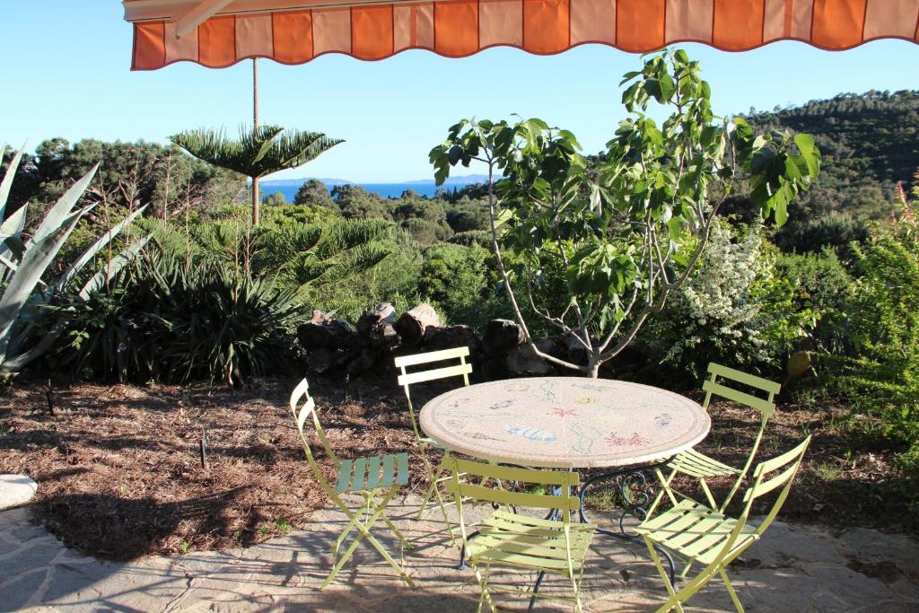 una mesa y sillas sentadas bajo una sombrilla en Carpe Diem en Le Lavandou