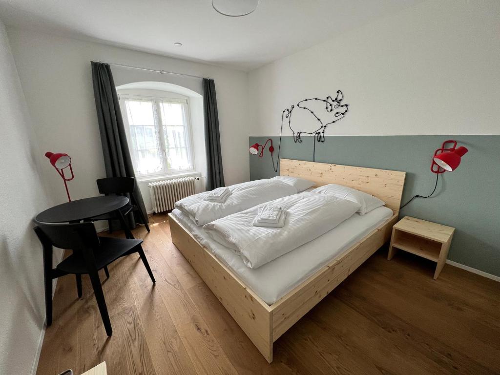 um quarto com uma cama, uma secretária e uma mesa em Berghof Erlebnis AG em Pfaffnau