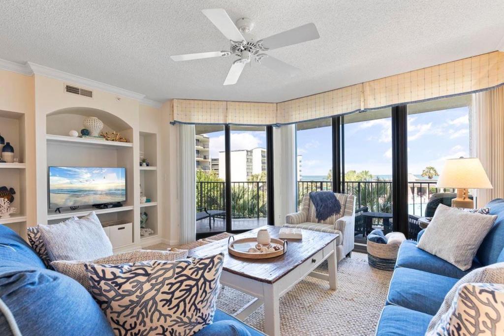 a living room with blue couches and a table at Captain's Quarters Upscale 3 Bedroom Condo in Pawleys Island