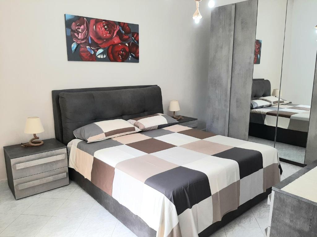 a bedroom with a black and white bed and a mirror at La casa di Nino in Portici