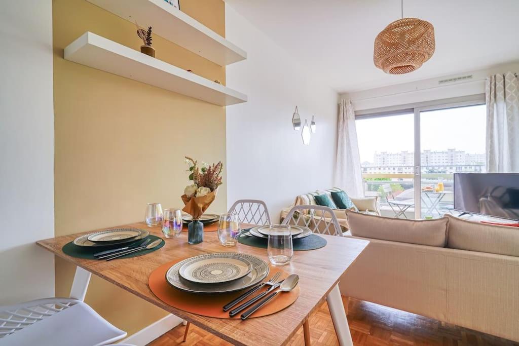 a dining room with a table and a couch at Rubis luxe proche Paris in Choisy-le-Roi