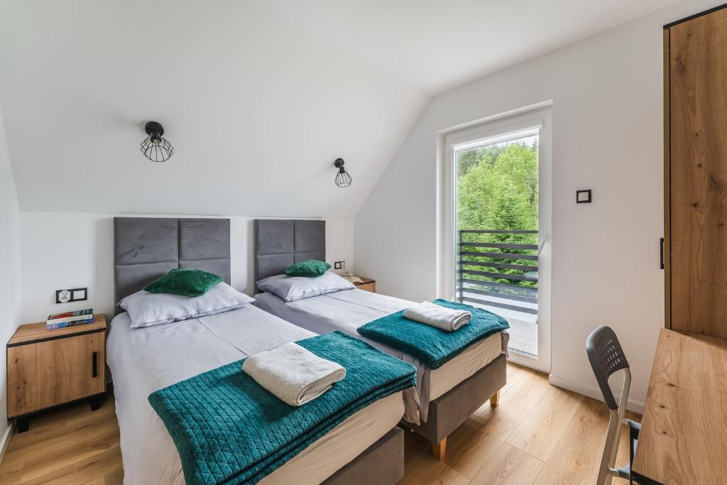 a bedroom with a large bed and a window at Domek RogatY in Szczawnica