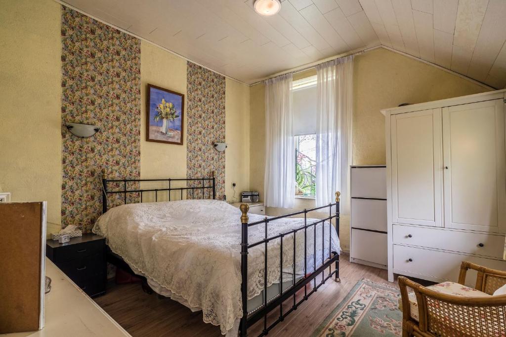ein Schlafzimmer mit einem Bett, einer Kommode und einem Fenster in der Unterkunft Achter de Vesting in Bourtange
