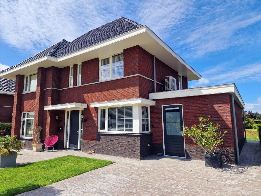 een rood bakstenen huis met een zwarte deur bij Studio Flevo Batavia in Lelystad