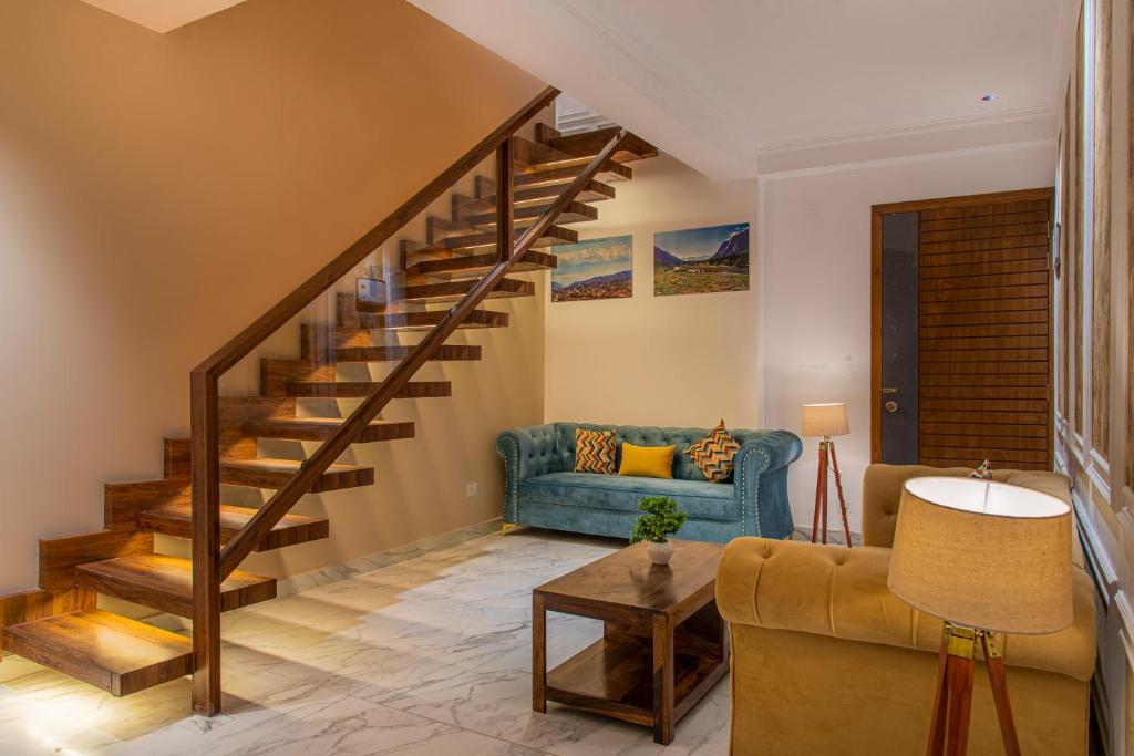 a living room with a blue couch and stairs at Kasauli Delight by Black Pearl in Kasauli