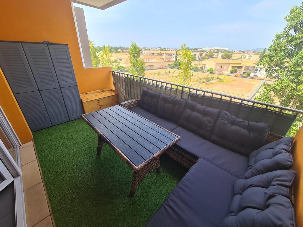 - un salon avec un canapé et une table sur un balcon dans l'établissement Studio à Fréjus, à Fréjus