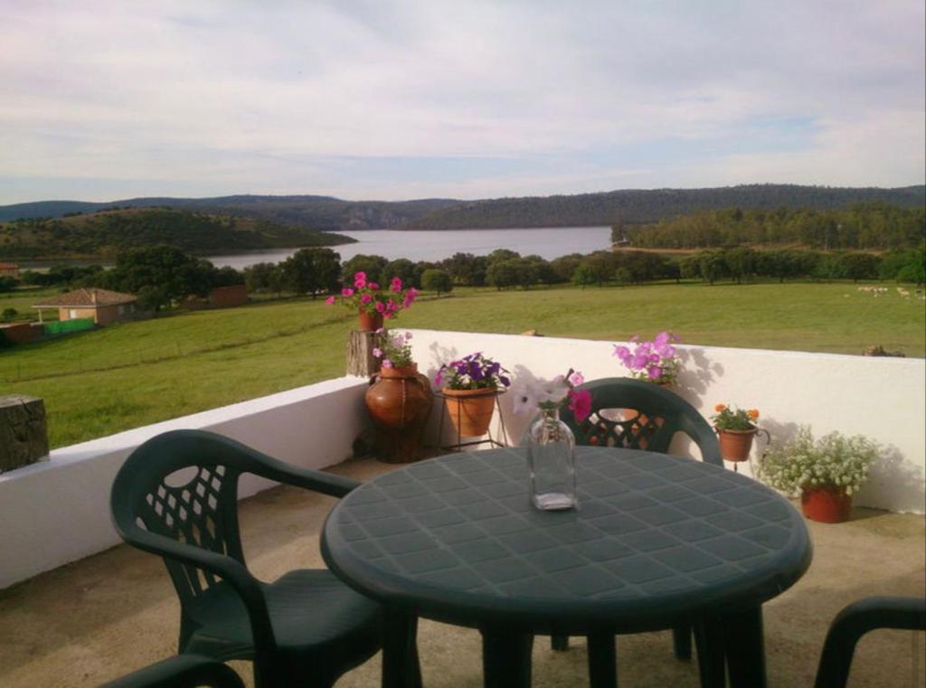 una mesa azul y sillas en un balcón con vistas en Apartamentos Las Abuelas, en Helechosa