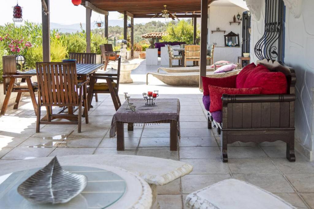 un patio con muebles de madera, mesa y sillas en Comfortable Triplex 5 Min to the Beach with Garden in Bodrum, en Bodrum City