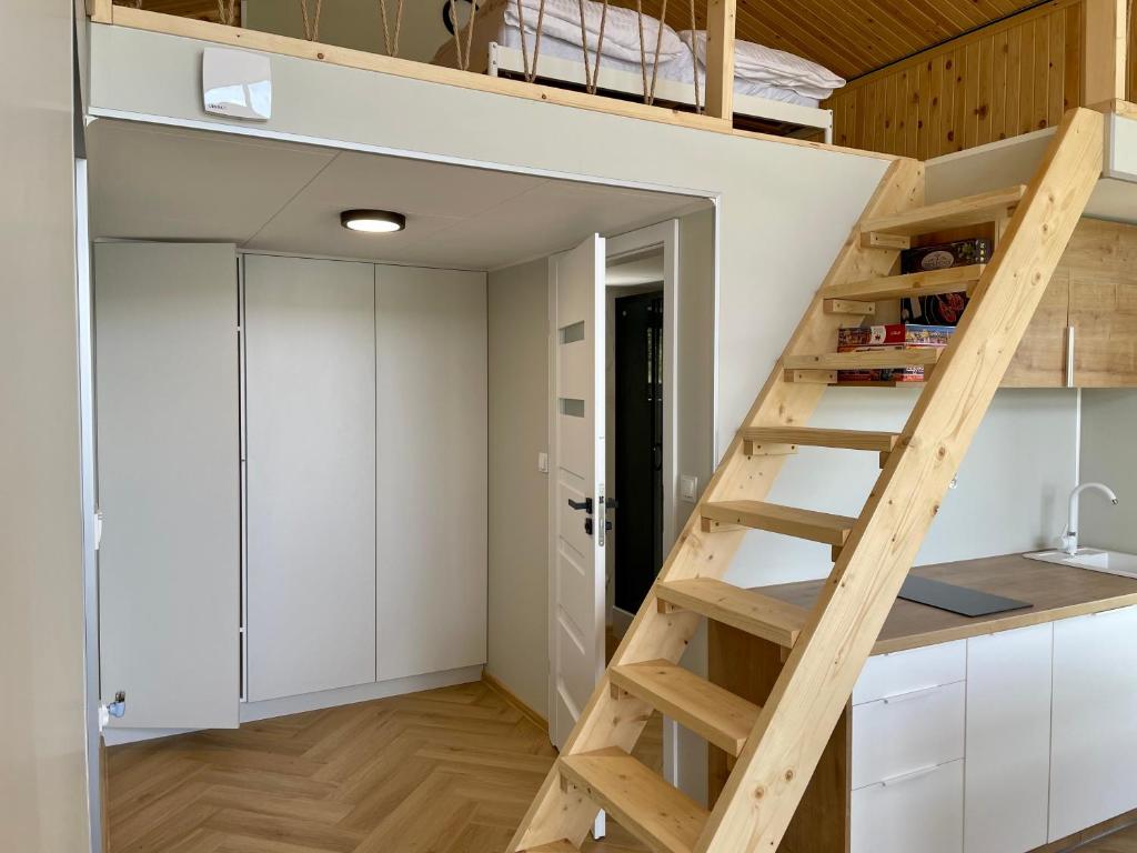 a room with a loft bed and white cabinets at Osada Jaćwingów in Gołdap