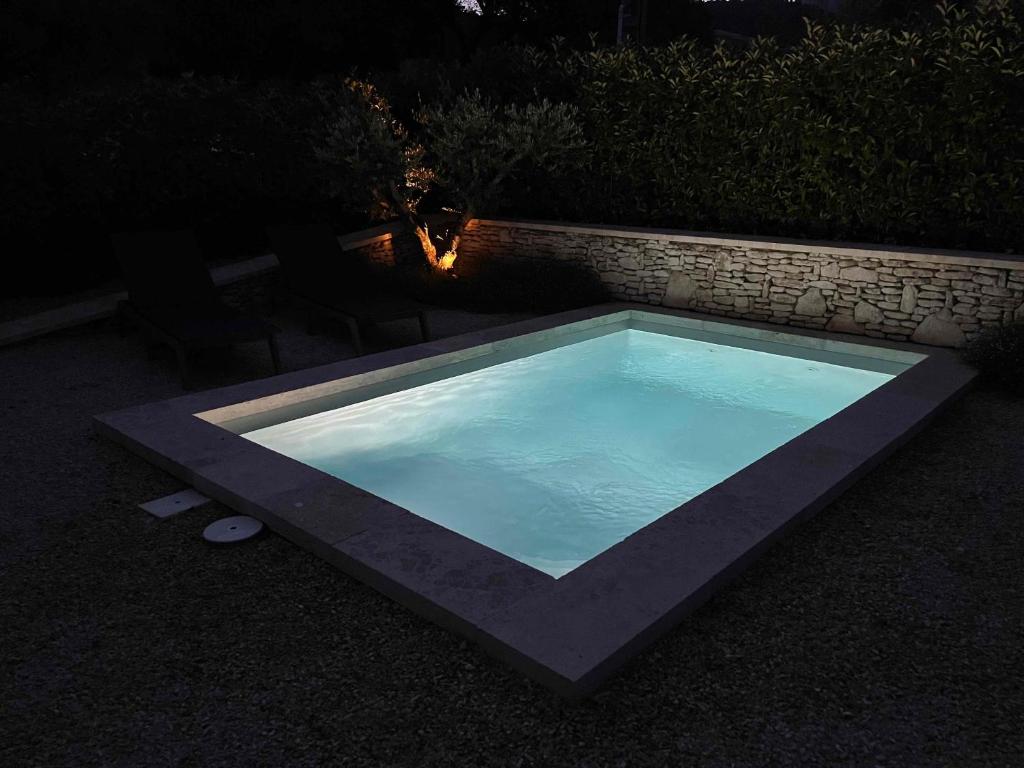 - une grande piscine dans la cour la nuit dans l'établissement Le Cabanon de Livia avec piscine privée, à Cucuron