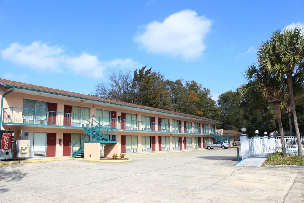 un edificio con un estacionamiento delante de él en Travelers Inn Gainesville, en Gainesville