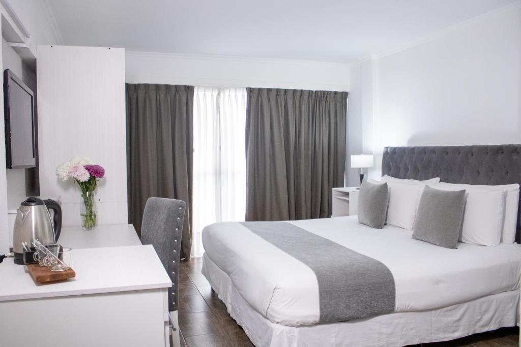 Habitación de hotel con cama, escritorio y cama sidx sidx en Ker Recoleta Hotel en Buenos Aires