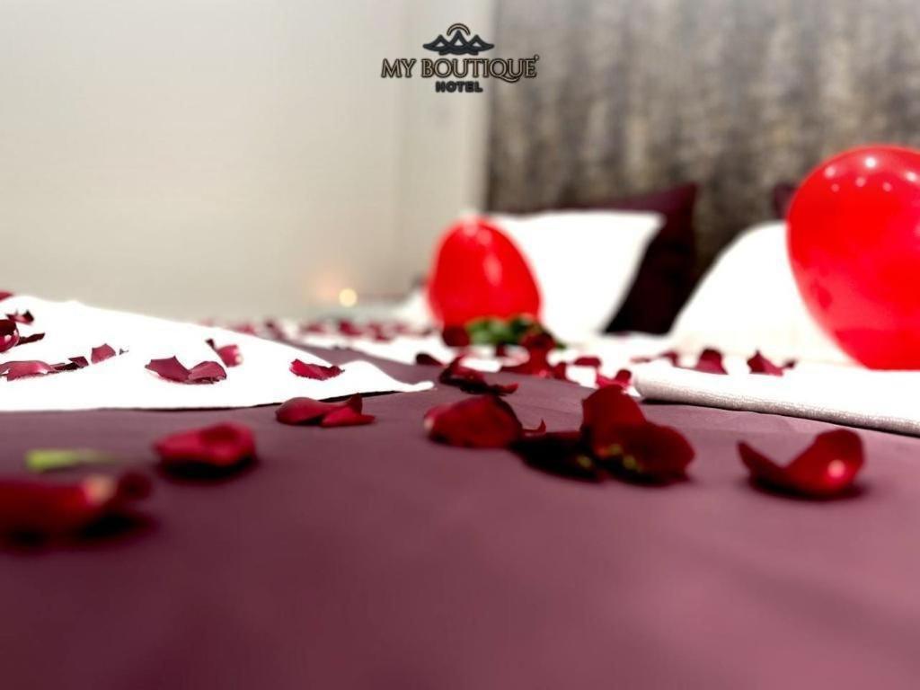a bunch of roses laying on a bed with a table at Alanya My Boutique Hotel in Alanya