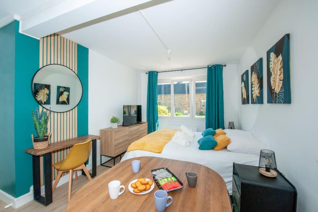 a bedroom with a bed and a desk and a table at Appartement Proche Gare Routière in Fougères