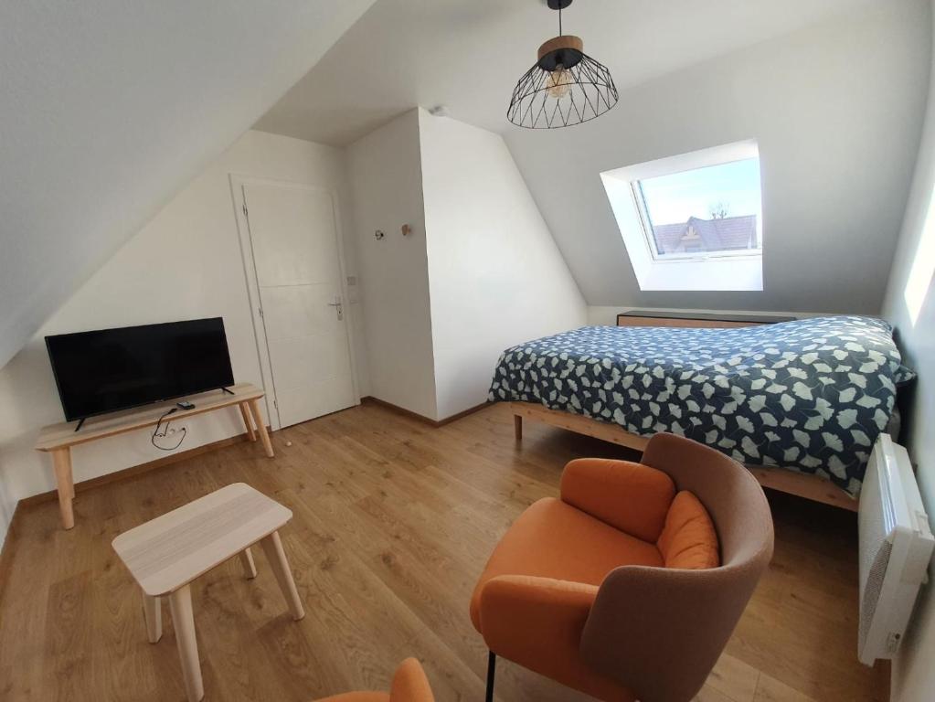 a small bedroom with a bed and a chair at Granne de Lin étage in Tourville