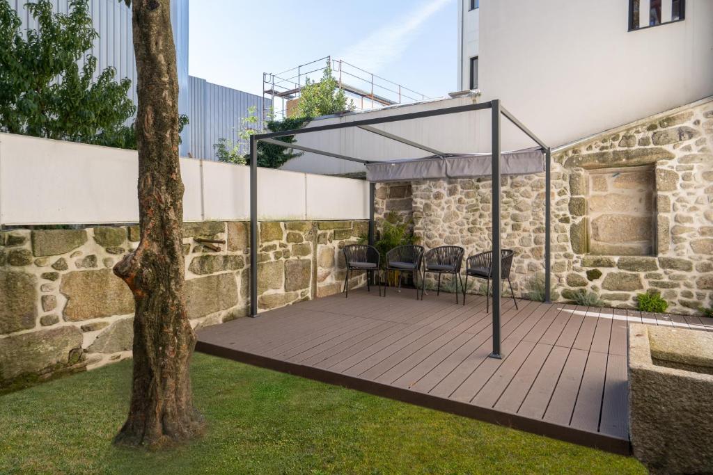 un patio con dosel y un árbol en Refreshing Cozy Flat - Garden & Terrace, en Oporto