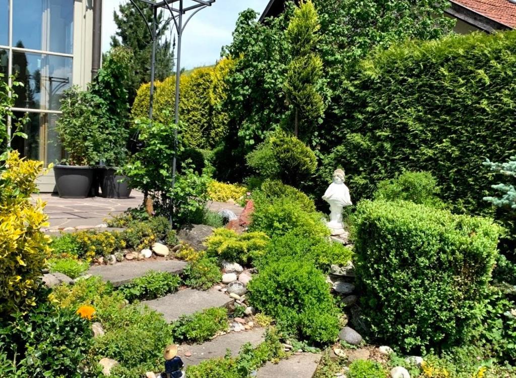 a garden with bushes and flowers in a house at Ferienwohnung SISSI in Rieden