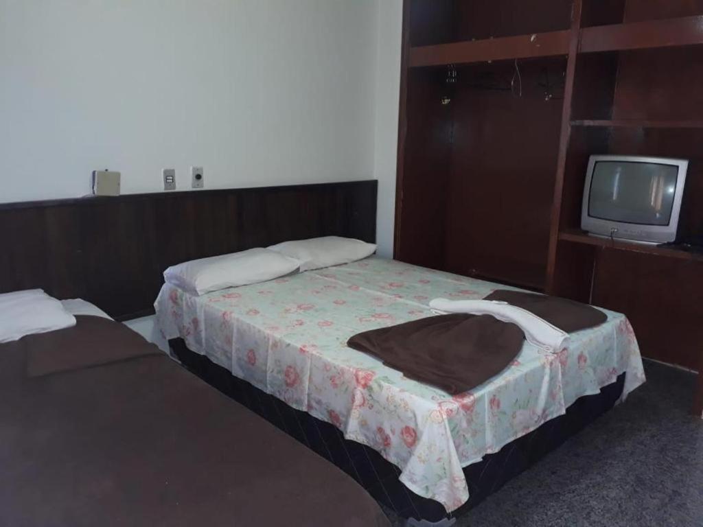 ブラジリアにあるBeiruth Hotelのベッド2台とテレビが備わるホテルルームです。