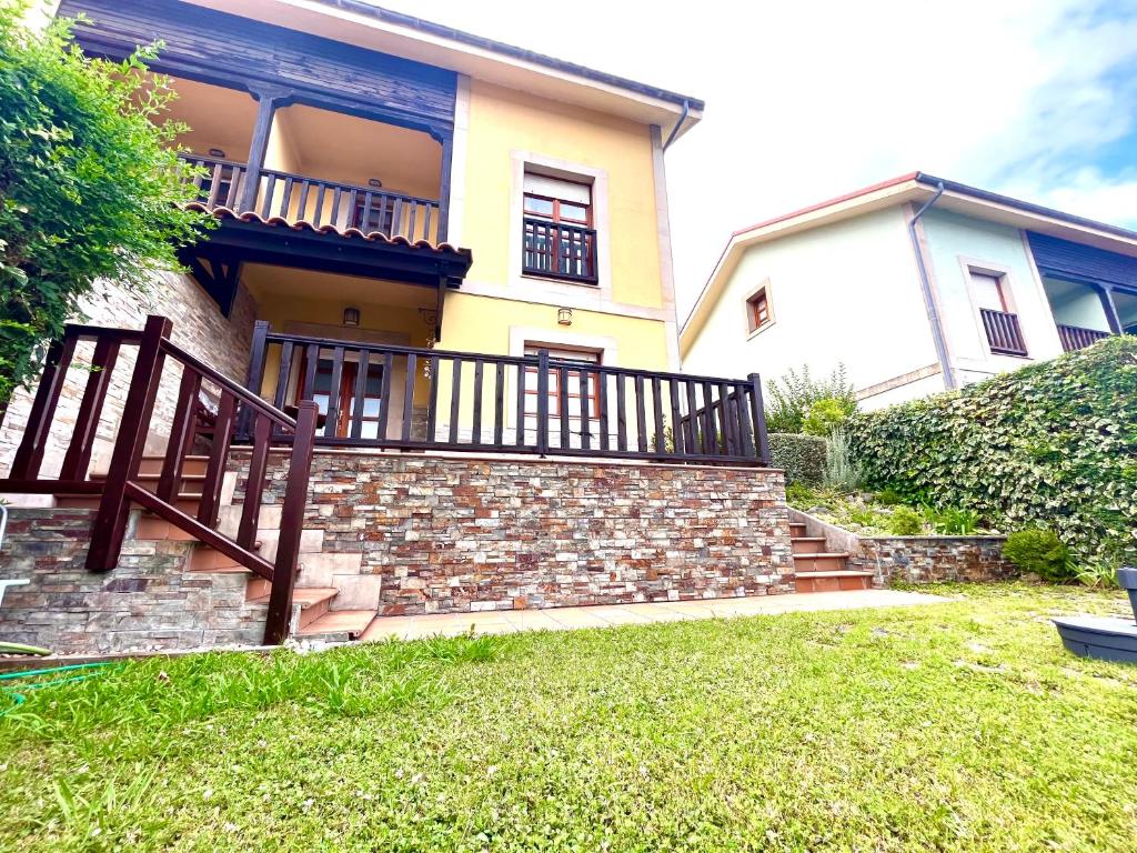 a house with a balcony and stairs in a yard at Chalet adosado en Ribadesella in Ribadesella