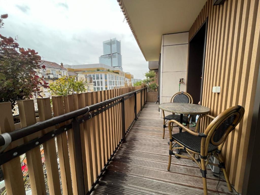 a balcony with two chairs and a table on it at Appartement Luxueux 3 pièces climatisé avec Terrasse, 5 couchages - 17ème Arrondissement de Paris in Clichy