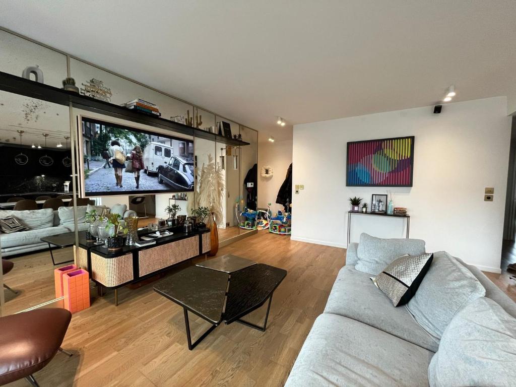 a living room with a couch and a flat screen tv at Appartement Luxueux 3 pièces climatisé avec Terrasse, 5 couchages - 17ème Arrondissement de Paris in Clichy