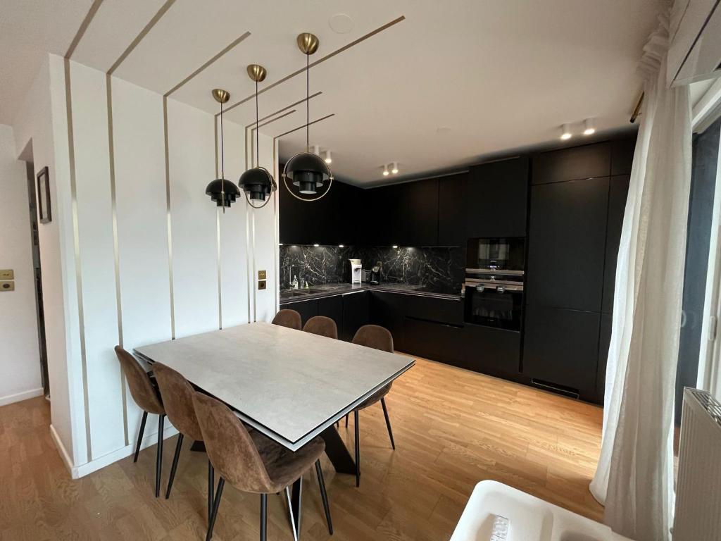 a kitchen and dining room with a table and chairs at Appartement Luxueux 3 pièces climatisé avec Terrasse, 5 couchages - 17ème Arrondissement de Paris in Clichy