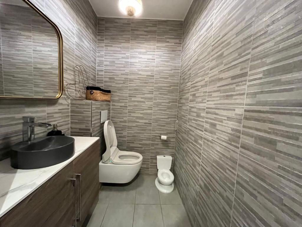 a bathroom with a sink and a toilet at Appartement Luxueux 3 pièces climatisé avec Terrasse, 5 couchages - 17ème Arrondissement de Paris in Clichy