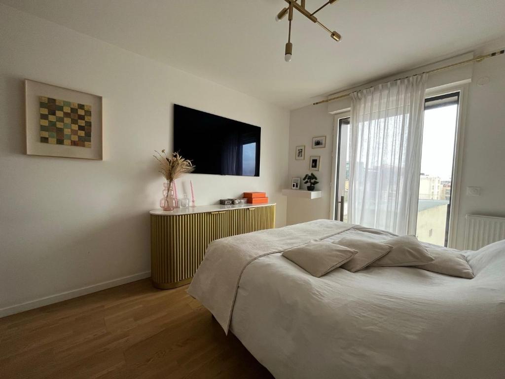 a bedroom with a bed and a flat screen tv at Appartement Luxueux 3 pièces climatisé avec Terrasse, 5 couchages - 17ème Arrondissement de Paris in Clichy
