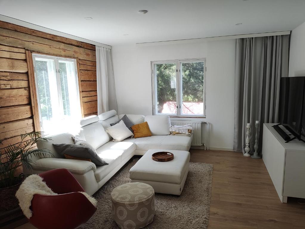 a living room with a white couch and a table at Unique villa by the lake in Lahti