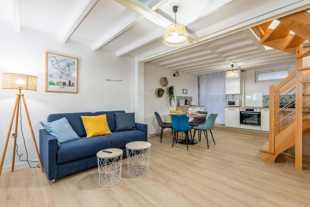 Beautiful flat in the heart of Lyon - Welkeys في ليون: غرفة معيشة مع أريكة زرقاء ومطبخ