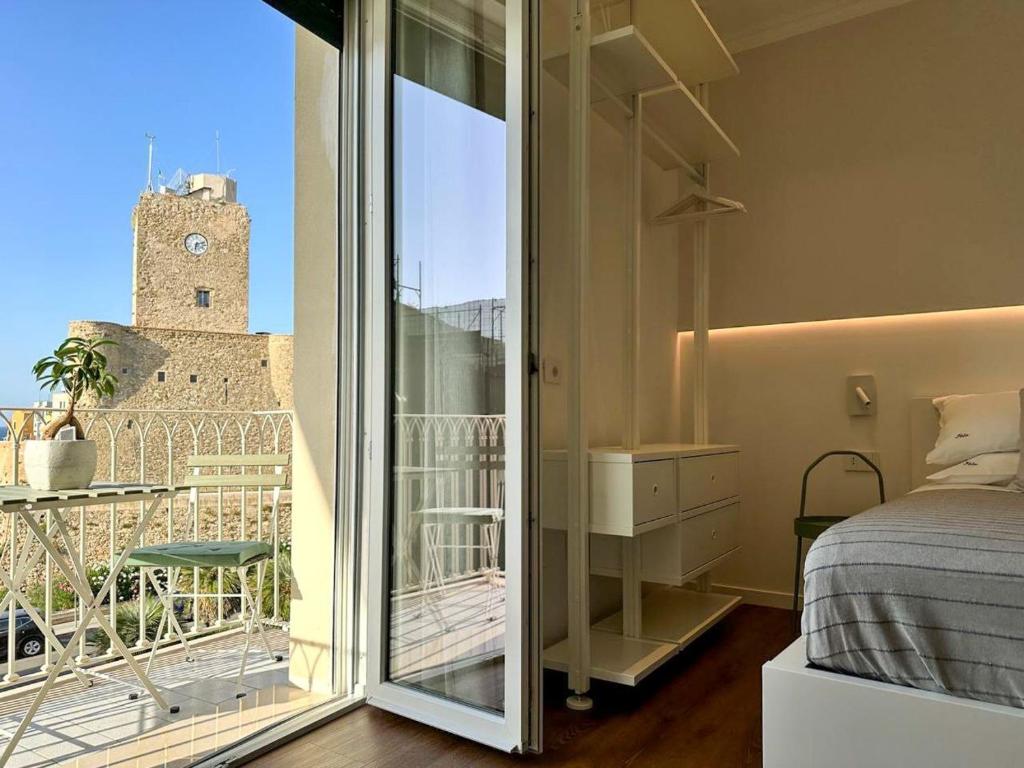 a bedroom with a bed and a balcony with a clock tower at Iblu Rooms in Termoli