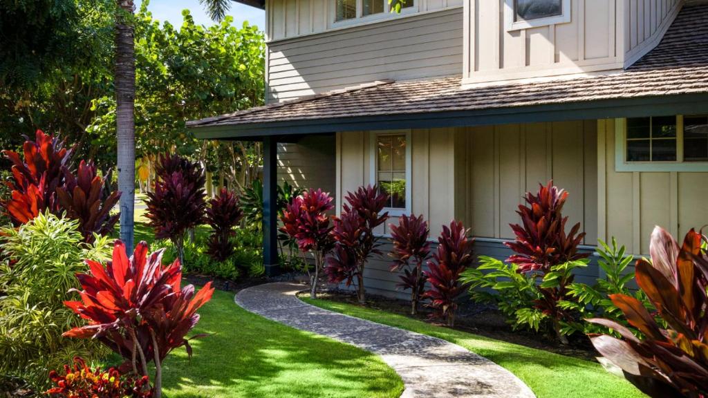 ein Haus mit roten Blumen im Hof in der Unterkunft Kulalani at Mauna Lani 2301 in Waikoloa