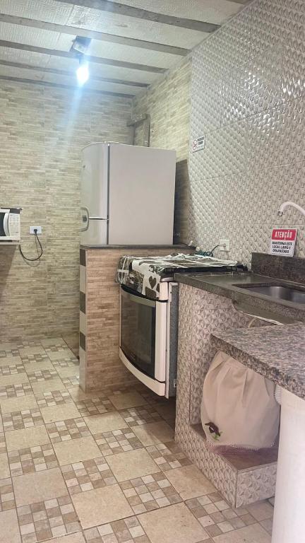 eine Küche mit einer Mikrowelle und einem Kühlschrank in der Unterkunft GL Pousada in Guarujá