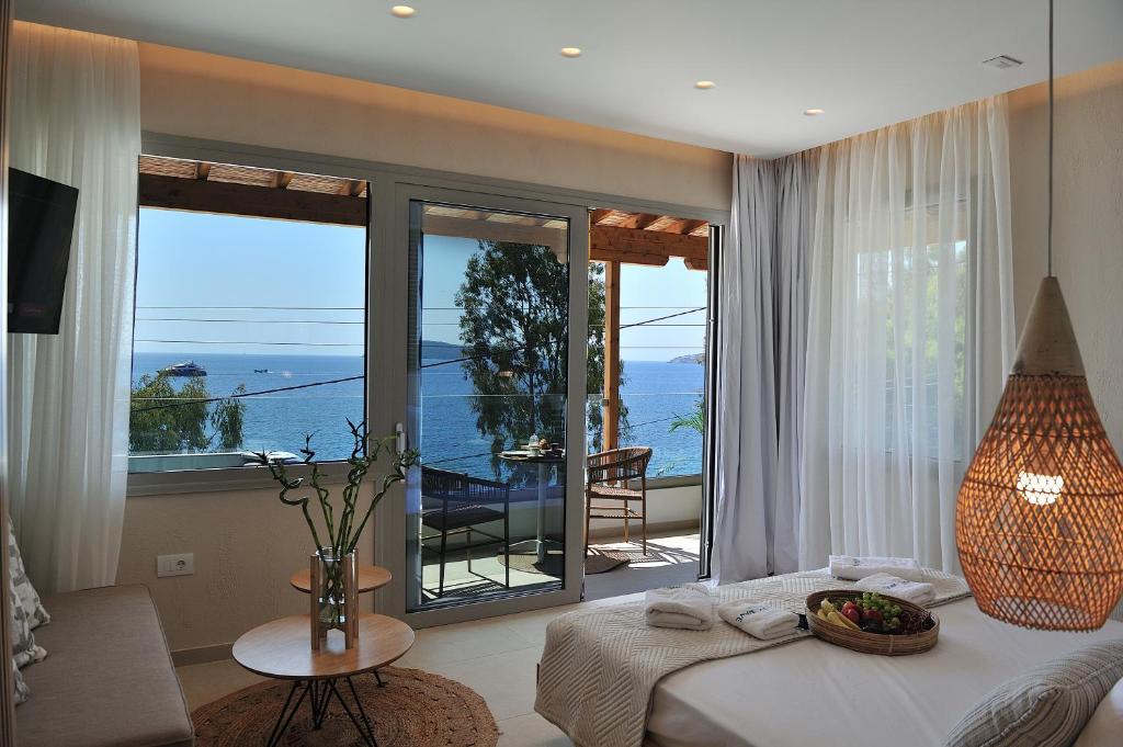 a bedroom with a bed and a view of the ocean at Salty Wave Suites in Skiathos Town